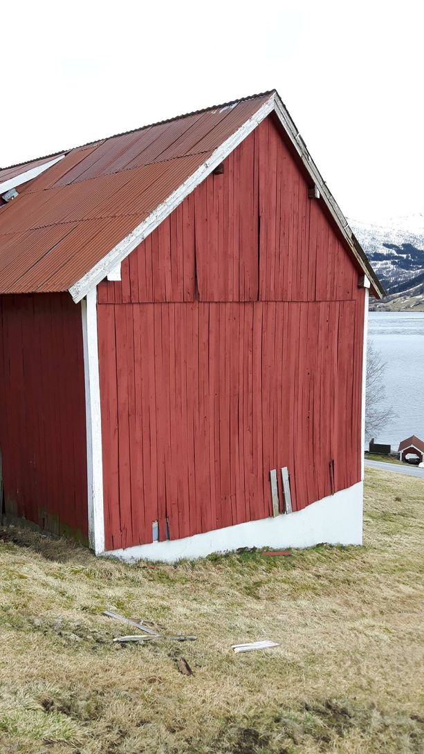 En gammel rød løe før bordkledningen ble skiftet ut 
