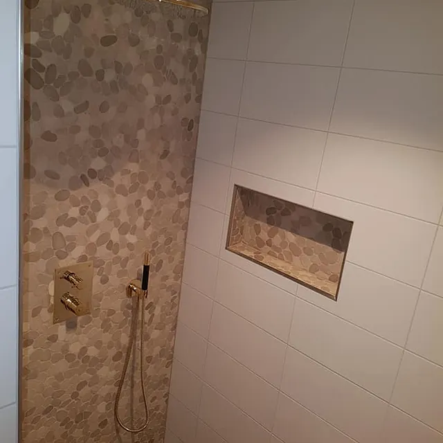 Dusj med vannfall og vanlig dusjhode, innebygd hylle og flislagte vegger og gulv